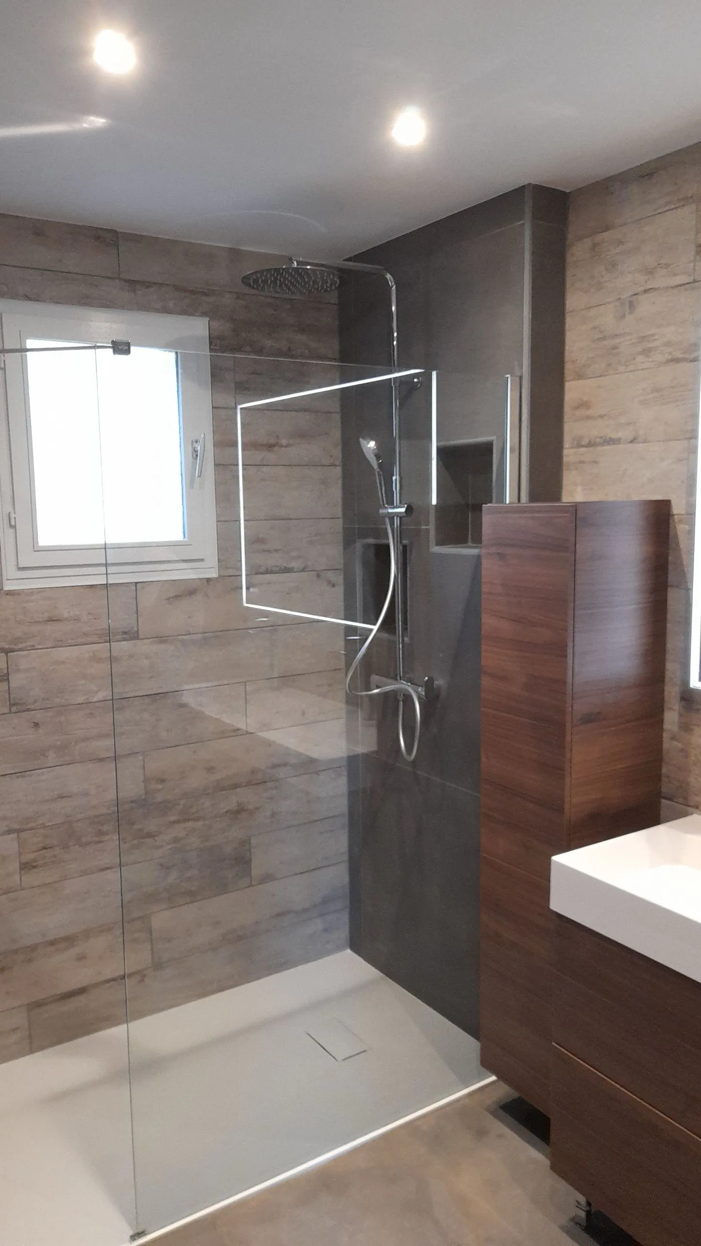 Salle de bain rénovée avec douche à l'italienne vitrée et meuble en bois
