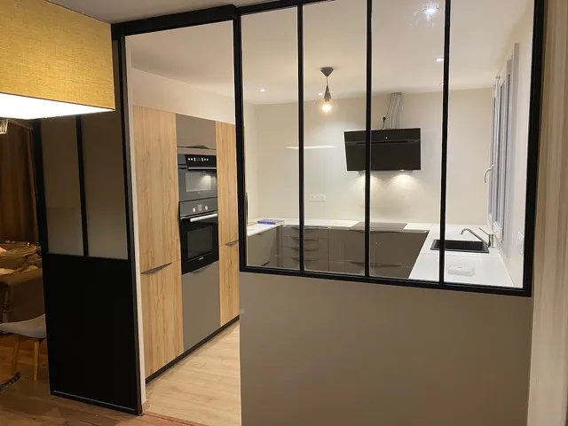 Cuisine rénovée avec verrière noire et électroménager encastré