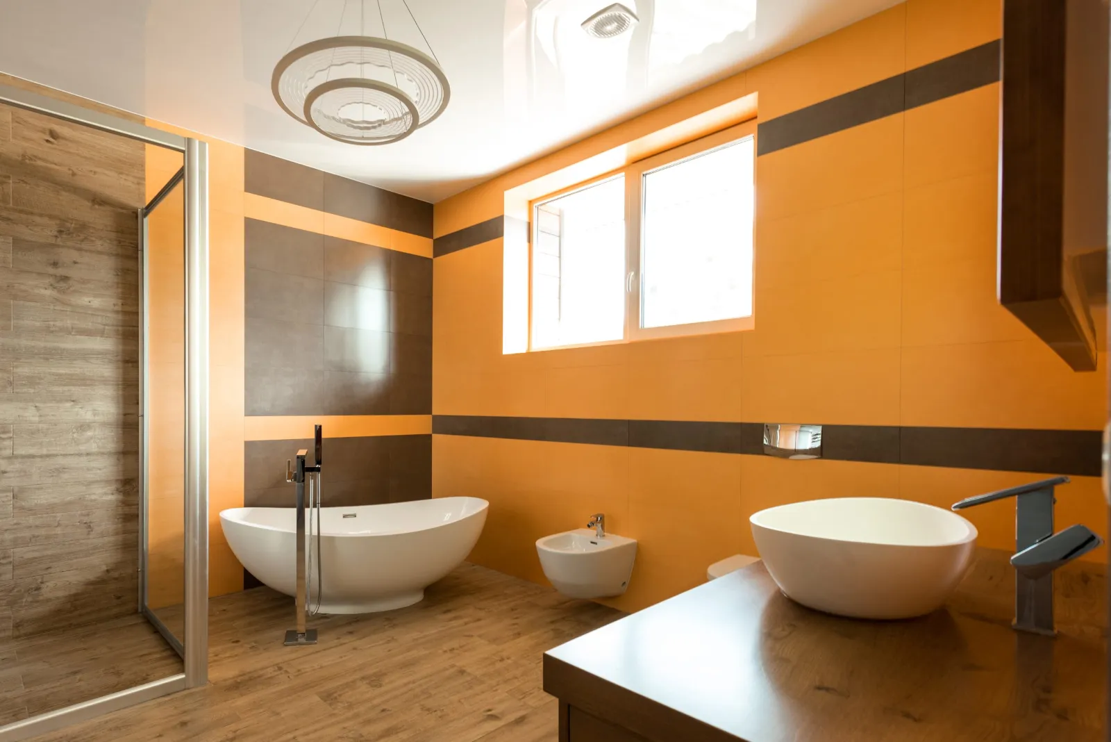 Salle de bain avec baignoire îlot et mur orange