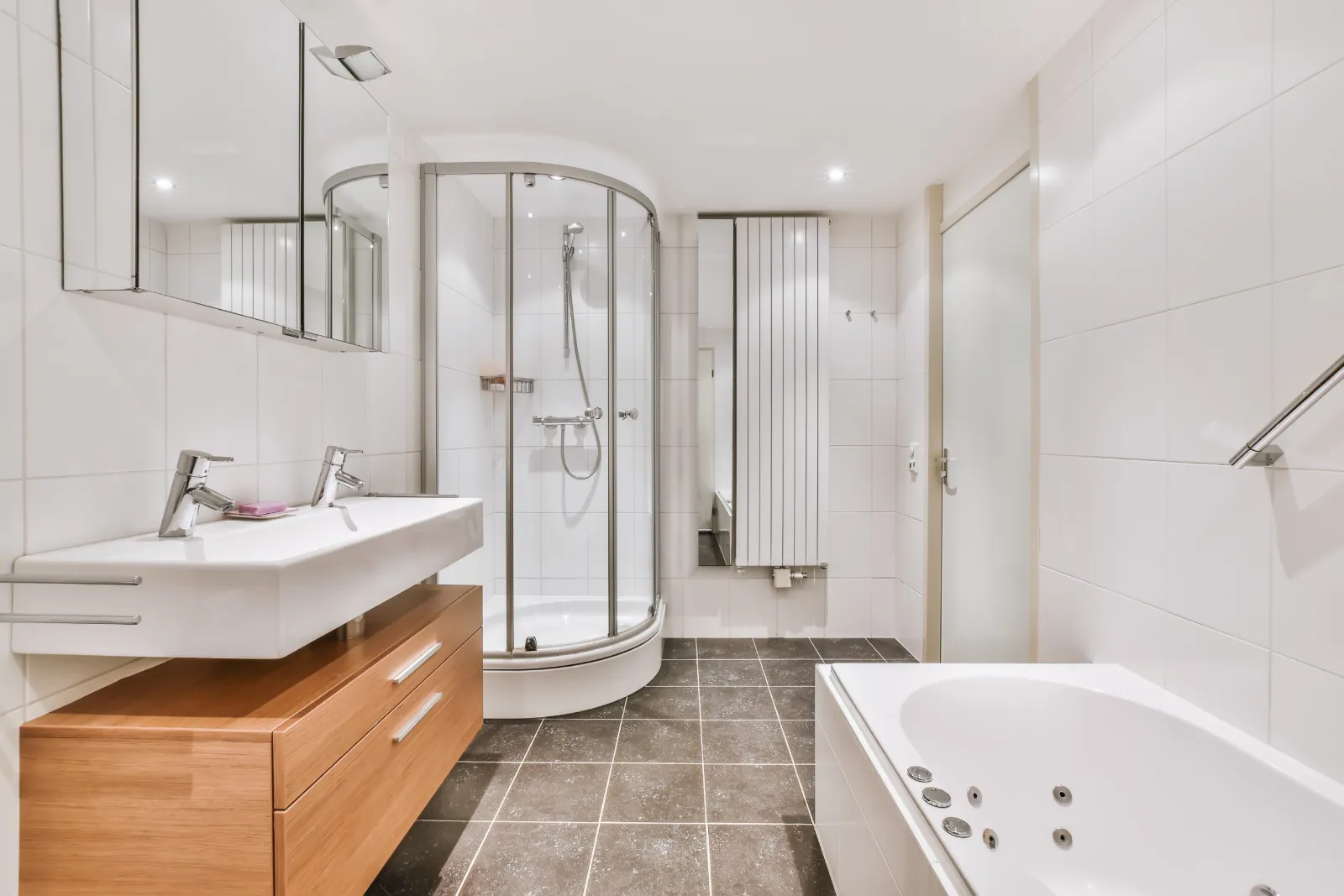 Salle de bain blanche avec cabine de douche et baignoire