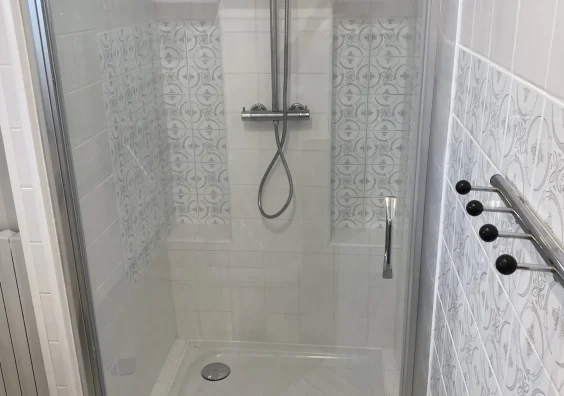 Douche à l'italienne avec colonne de douche et faïence blanche